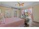 Comfortable main bedroom with ceiling fan and access to the outdoor patio and fountain at 5110 Championship Cup Ln, Spring Hill, FL 34609