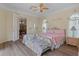 Cozy main bedroom with ceiling fan, windows with decorative sheers and entry into the dining room at 5110 Championship Cup Ln, Spring Hill, FL 34609