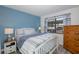 Charming bedroom with a white bed frame, blue accent wall, and natural light from the window at 5640 Ferguson Ct # 2106, New Port Richey, FL 34652