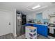 Bright kitchen featuring blue lower cabinets, stainless steel appliances, white cabinets and recessed lights at 5640 Ferguson Ct # 2106, New Port Richey, FL 34652