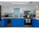 Bright kitchen featuring blue lower cabinets, stainless steel appliances, and white upper cabinets at 5640 Ferguson Ct # 2106, New Port Richey, FL 34652
