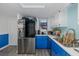 Well-lit kitchen featuring blue lower cabinets, stainless steel appliances, and white upper cabinets at 5640 Ferguson Ct # 2106, New Port Richey, FL 34652