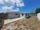 View of the backyard featuring a wood fence, a gray house and a spacious patio area at 5651 Canosa Dr, Holiday, FL 34690