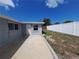 Backyard view with a concrete patio, a gray house, and a white fence provides a serene outdoor space at 5651 Canosa Dr, Holiday, FL 34690