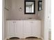 Bathroom vanity features marble countertop and white cabinets, accompanied by black framed mirrors at 5651 Canosa Dr, Holiday, FL 34690