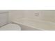 Bathroom with a white tiled tub and toilet at 5651 Canosa Dr, Holiday, FL 34690