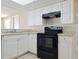 Kitchen with white cabinets and black appliances at 5651 Canosa Dr, Holiday, FL 34690
