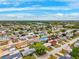 Wide aerial view of a residential neighborhood with tree-lined streets under a bright blue sky at 5706 Mockingbird Dr, New Port Richey, FL 34652