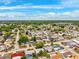 Aerial view of a residential neighborhood showing houses with tree-lined streets and blue skies at 5706 Mockingbird Dr, New Port Richey, FL 34652