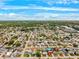 Wide aerial view of a residential neighborhood with tree-lined streets under a bright blue sky at 5706 Mockingbird Dr, New Port Richey, FL 34652