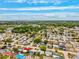 Wide aerial shot capturing a suburban neighborhood with a mix of housing, mature trees, and clear streets under a vibrant, partly clouded sky at 5706 Mockingbird Dr, New Port Richey, FL 34652