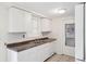 Well-lit kitchen with white cabinets, updated countertops, and stainless steel double sink at 5706 Mockingbird Dr, New Port Richey, FL 34652