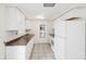 Well-lit kitchen featuring white cabinetry and standard appliances at 5706 Mockingbird Dr, New Port Richey, FL 34652