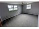 Bedroom features neutral paint, carpet, multiple windows, and a ceiling fan at 5949 1St Ave, New Port Richey, FL 34652