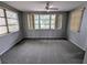 Bright living room with neutral paint, carpet, multiple windows, and a ceiling fan at 5949 1St Ave, New Port Richey, FL 34652