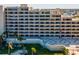 Condo building featuring multiple private balconies, a communal green area, and modern architectural design at 6035 Sea Ranch Dr # 209, Hudson, FL 34667