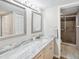 Bright bathroom with marble countertops, double sinks, updated lighting, and a glass enclosed shower at 6035 Sea Ranch Dr # 209, Hudson, FL 34667
