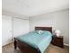 Cozy bedroom with wood-look floors, closet with louvered doors, side table, and a comfortable bed at 6035 Sea Ranch Dr # 209, Hudson, FL 34667