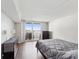 Bedroom with sliding glass doors open to a balcony with water views, a queen bed, and wood-look floors at 6035 Sea Ranch Dr # 209, Hudson, FL 34667