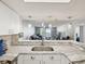 Bright kitchen boasts marble countertops, stainless steel sink, and open layout into the living area at 6035 Sea Ranch Dr # 209, Hudson, FL 34667