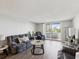 Light-filled living room with wood floors, access to balcony, and neutral decor for a serene ambiance at 6035 Sea Ranch Dr # 209, Hudson, FL 34667