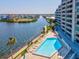 A condo building and pool are viewed from above, and across a canal from an island neighborhood at 6035 Sea Ranch Dr # 209, Hudson, FL 34667
