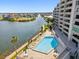 Beautiful waterfront condo building featuring a pool and lounge chairs at 6035 Sea Ranch Dr # 209, Hudson, FL 34667