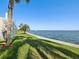 The waterfront has green grass, palm trees, and a view of the bay for relaxing at 6035 Sea Ranch Dr # 209, Hudson, FL 34667