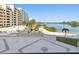 Scenic waterfront view from the balcony overlooking a sandy beach, palm trees, and bay waters at 6035 Sea Ranch Dr # 209, Hudson, FL 34667