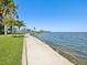 Picturesque waterfront walkway offering serene views of the bay, surrounded by lush greenery and palm trees at 6035 Sea Ranch Dr # 209, Hudson, FL 34667