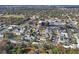 A captivating aerial perspective of a lush community with tree-lined streets, quaint homes, and serene pond views at 6047 Elmhurst Dr # 5A, New Port Richey, FL 34653