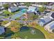 Aerial view of community recreation area with tennis courts, pool, and clubhouse overlooking a tranquil pond with fountain at 6047 Elmhurst Dr # 5A, New Port Richey, FL 34653