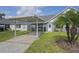 Home exterior with a carport, palm tree, well-manicured lawn, and tidy landscaping at 6047 Elmhurst Dr # 5A, New Port Richey, FL 34653