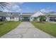Charming single-story home featuring a covered parking area, palm tree, and manicured lawn at 6047 Elmhurst Dr # 5A, New Port Richey, FL 34653