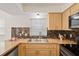 This bright kitchen has custom backsplash and matching cabinets at 6047 Elmhurst Dr # 5A, New Port Richey, FL 34653