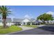 Street view of homes with carports, green lawns, and landscaping at 6047 Elmhurst Dr # 5A, New Port Richey, FL 34653