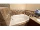 Bathroom with a soaking tub featuring tile surround and a granite vanity at 6054 Merrifield Dr, Zephyrhills, FL 33541