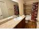 Bathroom features a shower with a tub, a baseball themed shower curtain, and dark wood cabinets at 6054 Merrifield Dr, Zephyrhills, FL 33541