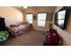 Bedroom featuring carpet floors, a ceiling fan, and two large windows at 6054 Merrifield Dr, Zephyrhills, FL 33541