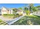 View of home's exterior with lush green lawn and walkway leading to the front door at 6054 Merrifield Dr, Zephyrhills, FL 33541