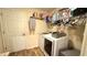 Laundry room featuring a front loading washer and dryer set and storage shelf at 6054 Merrifield Dr, Zephyrhills, FL 33541