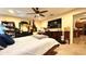 This main bedroom features a ceiling fan, TV, dresser, and access to the kitchen at 6054 Merrifield Dr, Zephyrhills, FL 33541