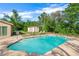 Private backyard pool with a storage shed and lush landscaping, perfect for outdoor enjoyment at 6104 Cork Ct, New Port Richey, FL 34653