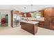 An updated kitchen with stainless steel appliances and a large island with granite countertop at 6104 Cork Ct, New Port Richey, FL 34653