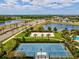 Aerial view of community sand volleyball court, basketball court, lake, and nearby roadway at 6229 Sea Air Dr, Apollo Beach, FL 33572