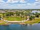 A scenic aerial view highlights a lakefront park bordered by mature trees and a walking path in a residential community at 6229 Sea Air Dr, Apollo Beach, FL 33572