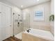 Well-lit bathroom featuring a soaking tub with a shower head, complemented by neutral tones and modern fixtures at 6229 Sea Air Dr, Apollo Beach, FL 33572