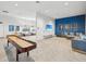 Community room with ample seating, tables, television, and shuffleboard table for residents at 6229 Sea Air Dr, Apollo Beach, FL 33572