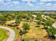 Aerial view of the fenced dog park with green grass, mature trees and walking path in a neighborhood with blue sky at 6229 Sea Air Dr, Apollo Beach, FL 33572