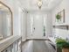 Bright foyer with a white front door, light wood floors, a bench, and decor touches at 6229 Sea Air Dr, Apollo Beach, FL 33572